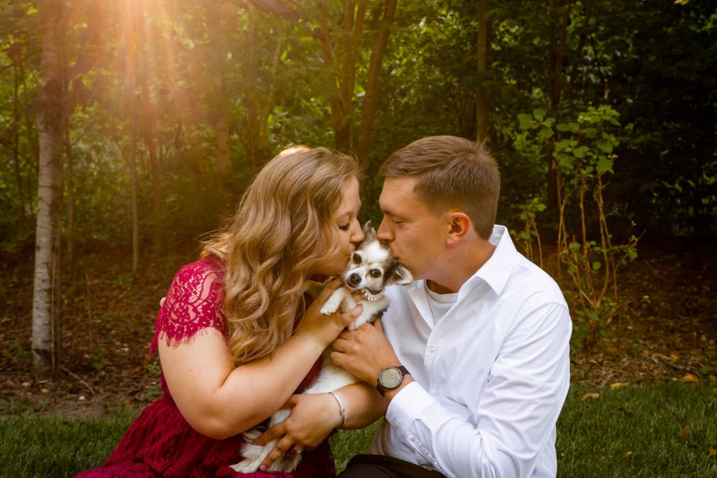 Couple kissing puppy-Don't Skip This! Fun Engagement Photo Session Ideas
